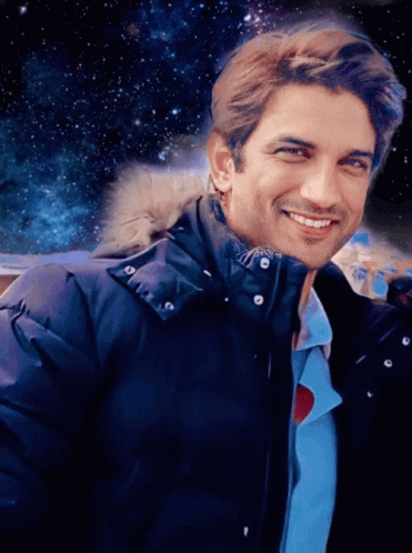 A Man Wearing A Blue Jacket With A Fur Hood Smiles GIF