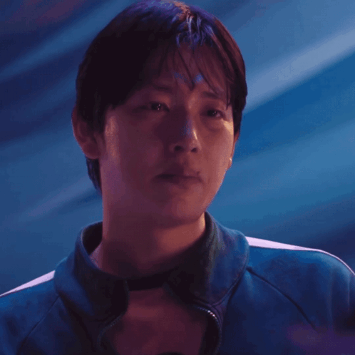 A Man Wearing A Blue Jacket With White Stripes On The Sleeves GIF