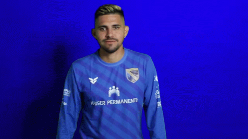 A Man Wearing A Blue Kaiser Permanente Jersey Looks Down GIF