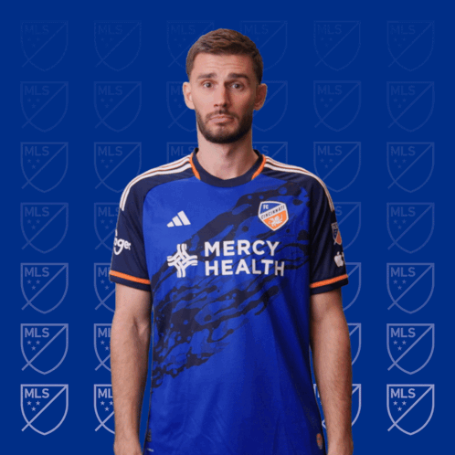 A Man Wearing A Blue Mercy Health Jersey Makes A Funny Face GIF