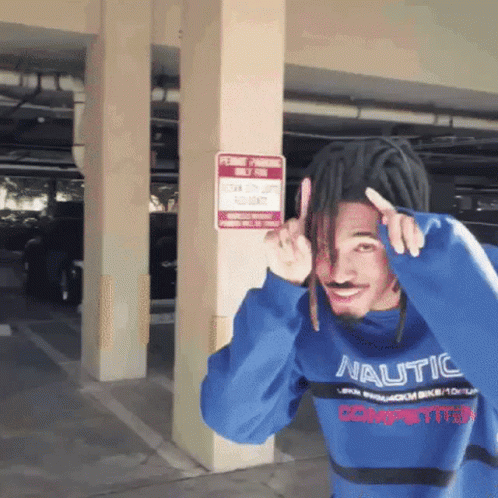 A Man Wearing A Blue Nautica Sweater Stands In Front Of A Permit Parking Sign GIF