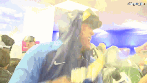A Man Wearing A Blue Nike Hoodie Stands In Front Of A Camera GIF