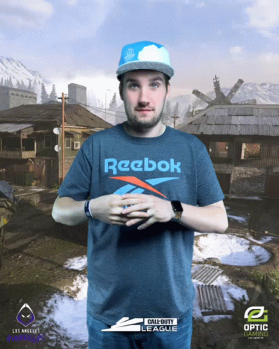 A Man Wearing A Blue Reebok Shirt Stands In Front Of A Call Of Duty Background GIF