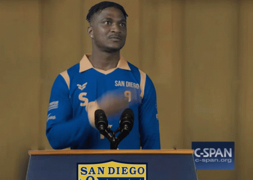 A Man Wearing A Blue San Diego Jersey Stands Behind A Podium GIF