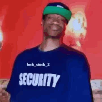 A Man Wearing A Blue Security Shirt Is Smiling GIF