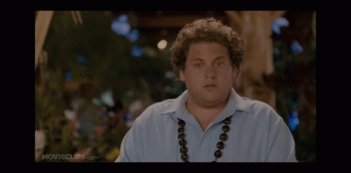 A Man Wearing A Blue Shirt And A Necklace Is On A Movie Clip GIF