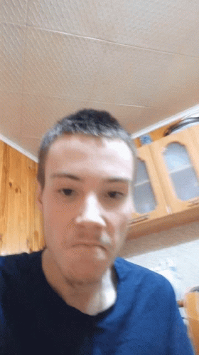 A Man Wearing A Blue Shirt Is Making A Funny Face GIF