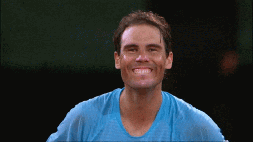 A Man Wearing A Blue Shirt Is Smiling With His Eyes Closed GIF