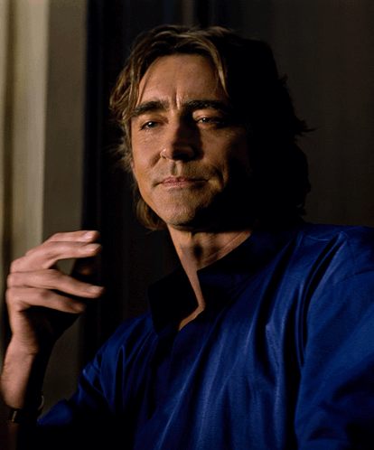 a man wearing a blue shirt is smoking a cigarette