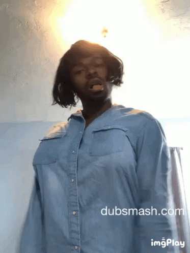 A Man Wearing A Blue Shirt Is Standing In Front Of A Wall With Dubsmash.com Written On The Bottom GIF