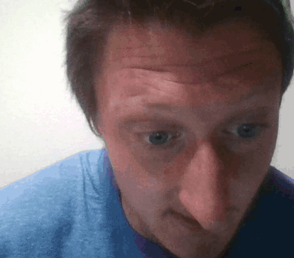 A Man Wearing A Blue Shirt Looks At The Camera GIF