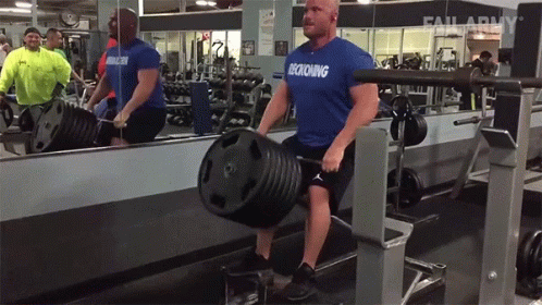 A Man Wearing A Blue Shirt That Says Decking Is Lifting A Barbell In A Gym GIF
