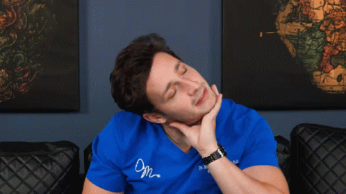 a man wearing a blue shirt that says dr. mike lombardi is holding his neck
