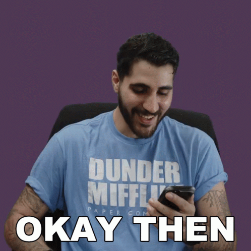 Man In Dunder Mifflin Shirt Looking At Phone GIF
