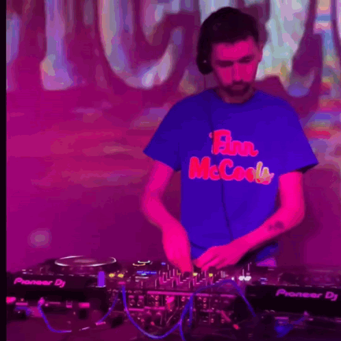 A Man Wearing A Blue Shirt That Says Flan Mccools Is Playing Music GIF