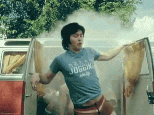 A Man Wearing A Blue Shirt That Says Jogging Is Standing In A Van . GIF