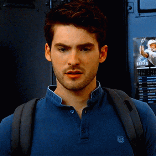 A Man Wearing A Blue Shirt With A Kenzo Logo On The Front GIF