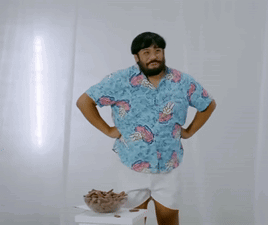 A Man Wearing A Blue Shirt With Pineapples On It GIF