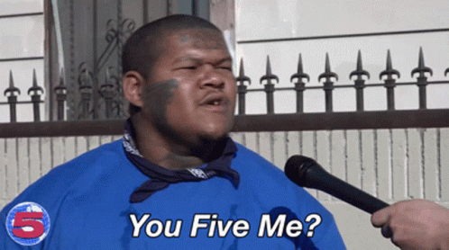 A Man Wearing A Blue Shirt With The Number 5 On It Is Talking Into A Microphone GIF