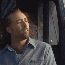 A Man Wearing A Blue Shirt With The Word Motors On The Front GIF