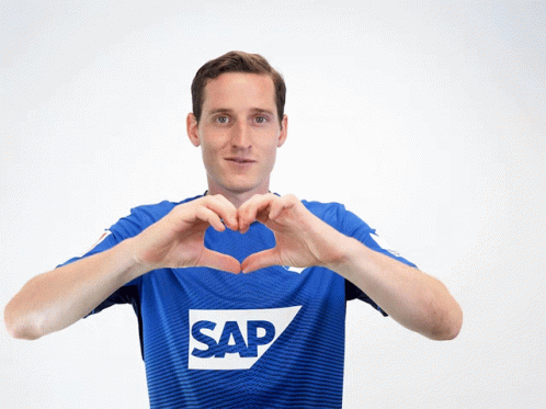 A Man Wearing A Blue Shirt With The Word Sap On It Makes A Heart Shape With His Hands GIF