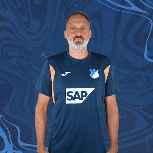 a man wearing a blue shirt with the word sap on the front