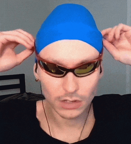 A Man Wearing A Blue Swim Cap And Sunglasses Adjusts His Sunglasses GIF