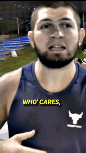 A Man Wearing A Blue Tank Top That Says Who Cares On It GIF