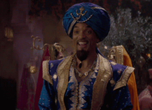 A Man Wearing A Blue Turban And A Blue And Gold Outfit Is Smiling GIF
