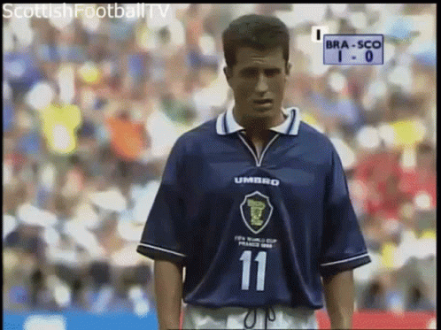A Man Wearing A Blue Umbro Jersey Stands On A Field GIF