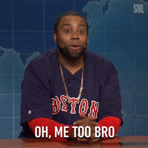 a man wearing a boston jersey is sitting at a table and says oh me too bro