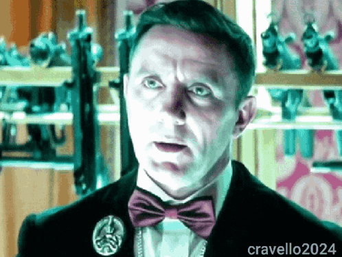 A Man Wearing A Bow Tie And A Pin With The Name Cravello2024 GIF