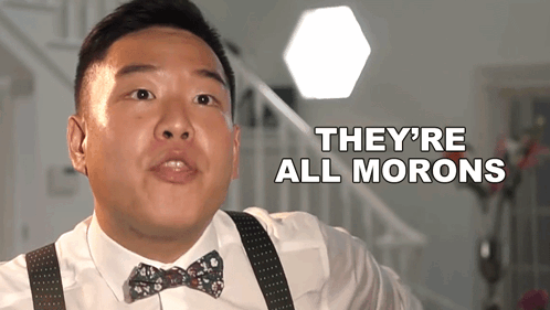 A Man Wearing A Bow Tie And Suspenders Says " They 'Re All Morons " GIF