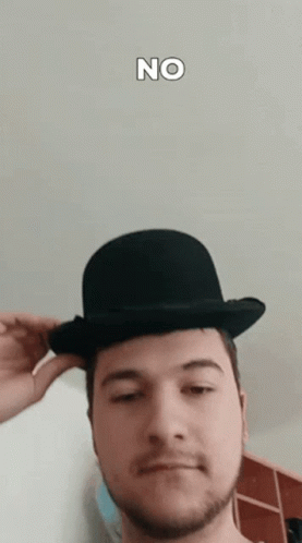 a man wearing a bowler hat with the word no on the bottom right