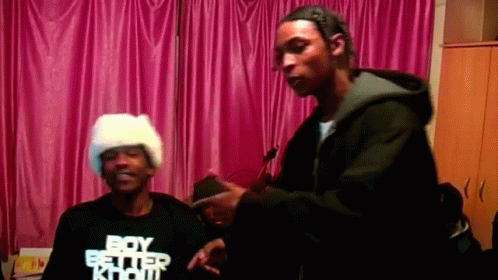 A Man Wearing A Boy Better Know T-Shirt Stands Next To Another Man GIF