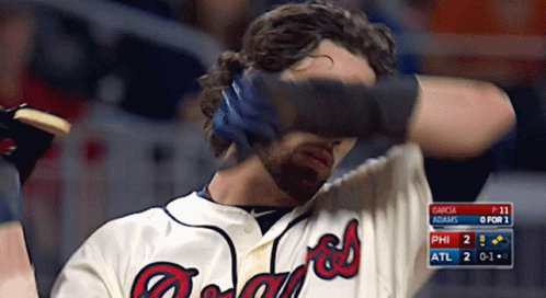 A Man Wearing A Braves Jersey Covers His Eyes GIF