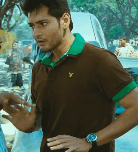 A Man Wearing A Brown And Green Polo Shirt With A Yellow Eagle On It GIF