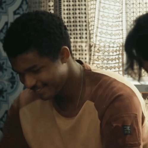 A Man Wearing A Brown Shirt With A Label On The Sleeve That Says ' Ao ' GIF