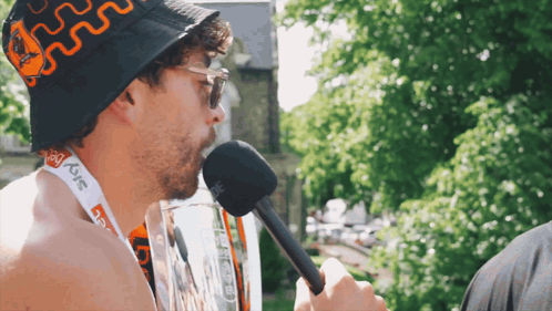A Man Wearing A Bucket Hat And A Lanyard That Says Sky On It GIF
