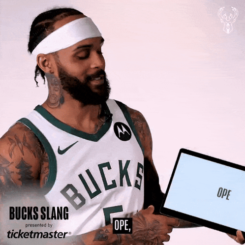 A Man Wearing A Bucks Jersey Is Holding A Tablet GIF