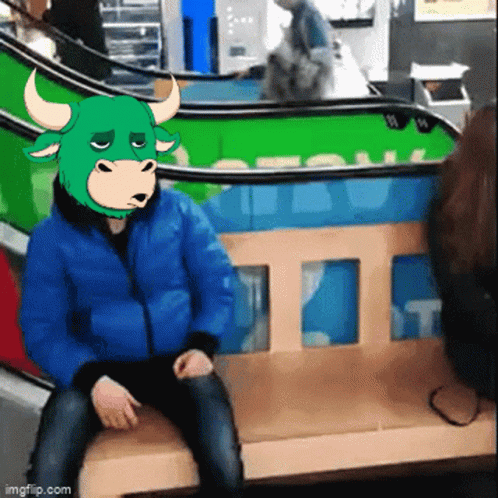 a man wearing a bull mask sits on a bench in front of an escalator