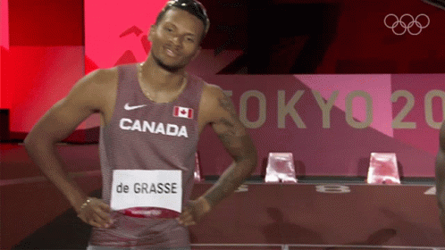 A Man Wearing A Canada Jersey Is Standing In Front Of A Tokyo 2020 Sign GIF
