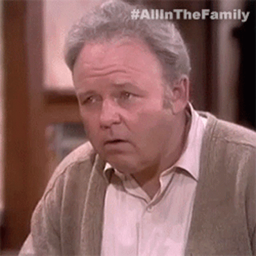 Man In Cardigan And White Shirt Looking At Camera GIF