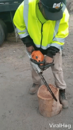 A Man Wearing A Cat Hat Is Using A Chainsaw GIF