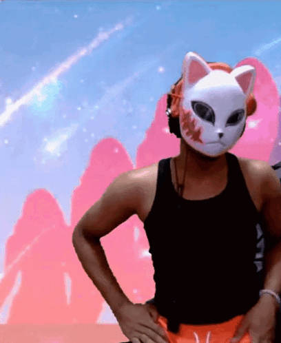 A Man Wearing A Cat Mask And Headphones Is Standing With His Hands On His Hips GIF