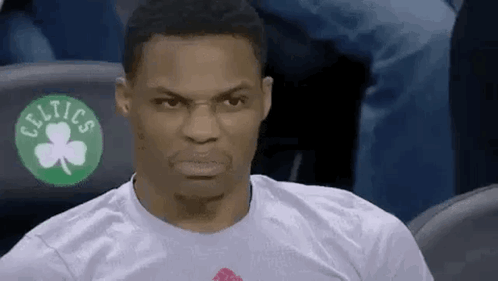 A Man Wearing A Celtics T-Shirt Is Sitting In The Stands Making A Funny Face . GIF