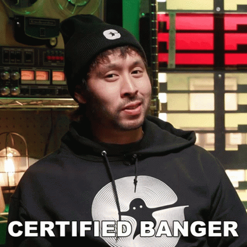 A Man Wearing A Certified Banger Hoodie Stands In Front Of A Record Player GIF