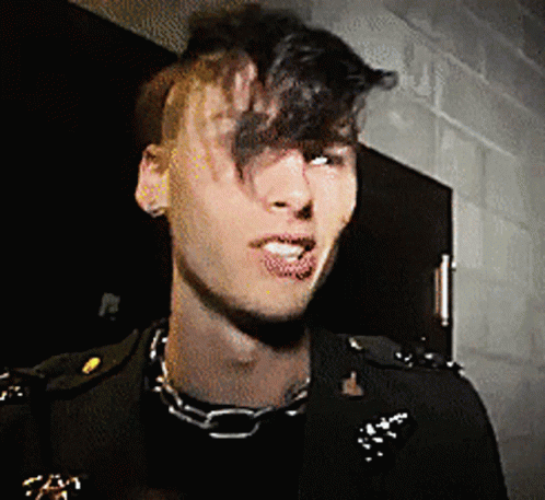A Man Wearing A Chain Around His Neck And A Black Jacket GIF