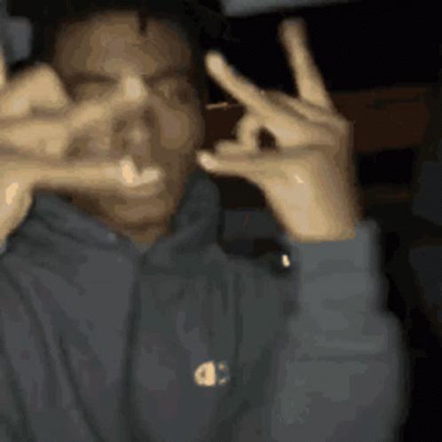 A Man Wearing A Champion Hoodie Making A Peace Sign With His Hands GIF