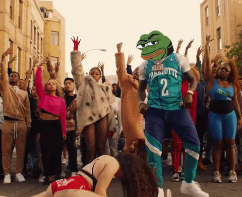 A Man Wearing A Charlotte 2 Jersey Is Dancing With A Crowd Of People GIF